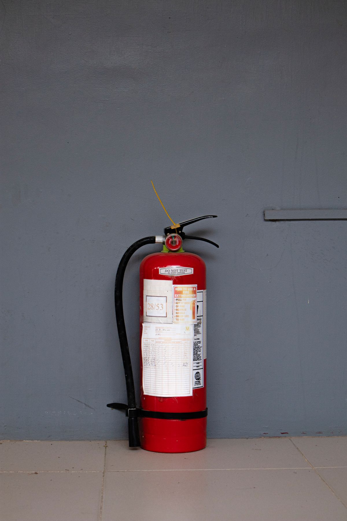 Wall-mounted fire extinguisher with a servicing inspection label