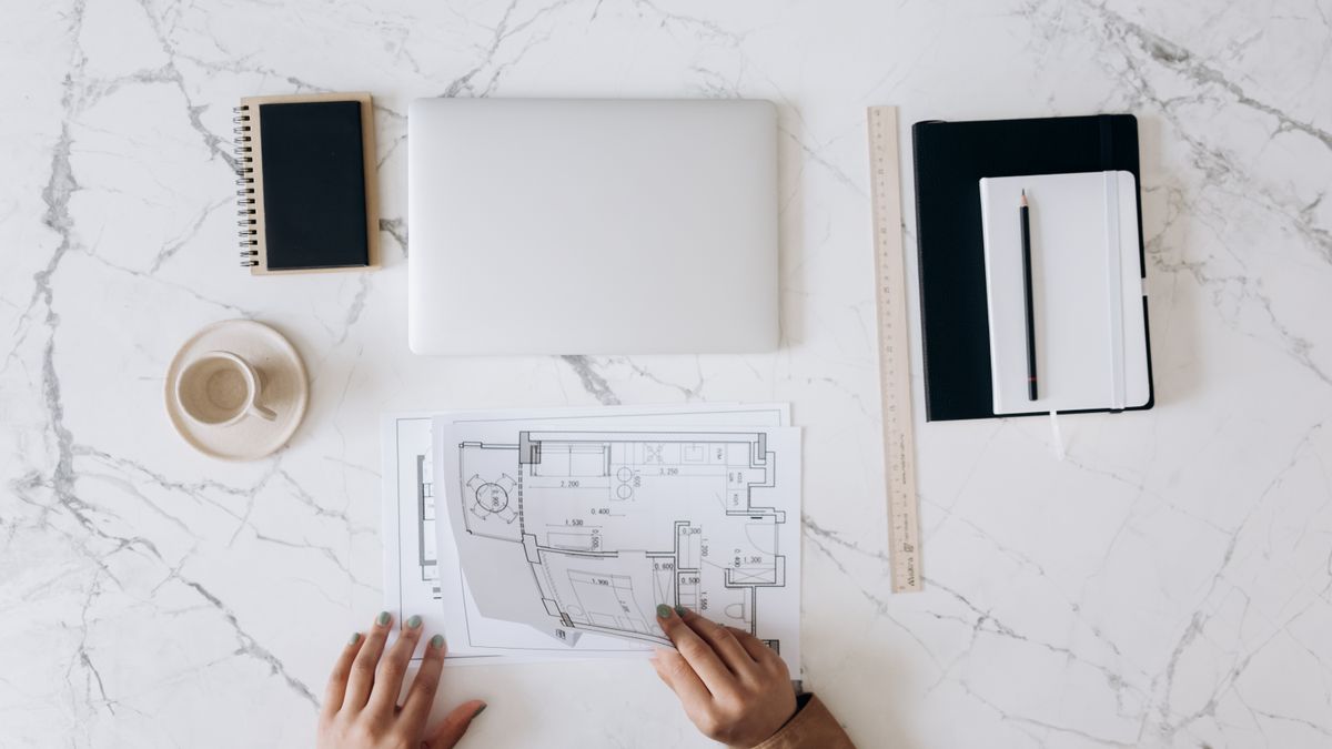 Architect reviewing a building floor plan at a desk
